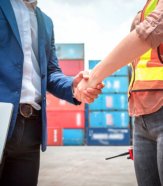Colaborador de Maverick Border Services y cliente estrechando las manos en puerto de contenedores, tras brindarle servicios de gestión aduanera y asesoría de comercio exterior